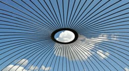 An image of a circular roof with clouds and blue sky, published in the Gloy Journal INOGOV Special Issue.